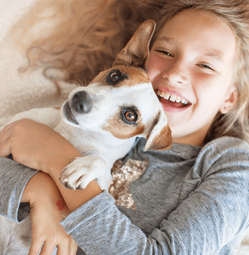 Little girl cuddling a dog